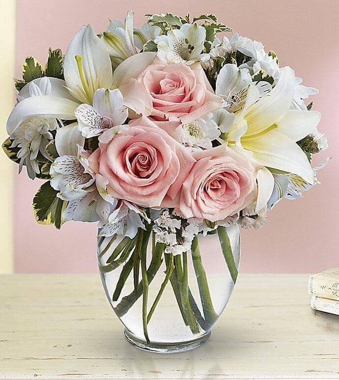 Arrive In Style - vase with Light pink roses, white asiatic lilies, white alstroemeria and white cushion spray chrysanthemums are mixed with white statice and variegated pittosporum