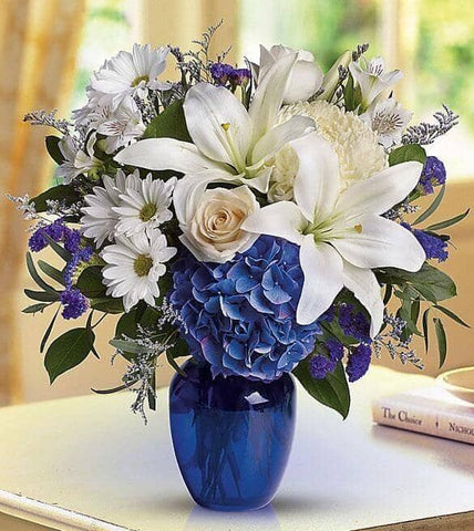 Beautiful in Blue - blue hydrangea , cream roses , white lilies , white alstroemeria , white mums , purple statice , lavender limonium , seeded eucalyptus , vase arrangement