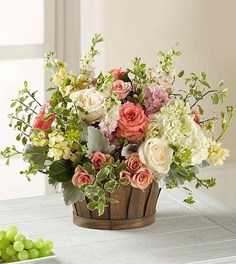 Bountiful Garden™ Bouquet - white roses , salmon roses , pink larkspur , cream gillyflower , peach spray roses , white hydrangea , dusty miller , basket arrangement