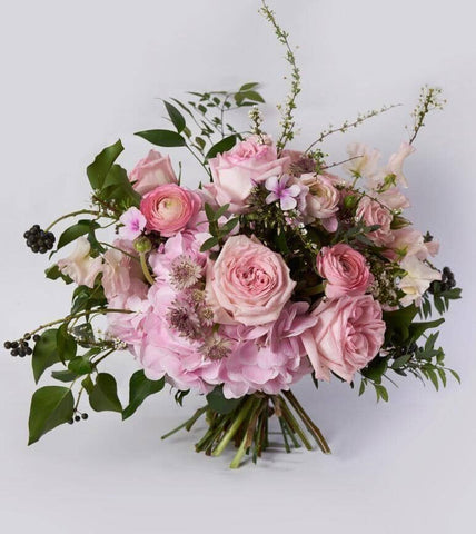 Pink Sensation Bouquet - featuring pink O’Hara Garden Roses, incredibly fragrant sweet peas, pink hydrangea, ranunculus that come accented with branches and lush greens